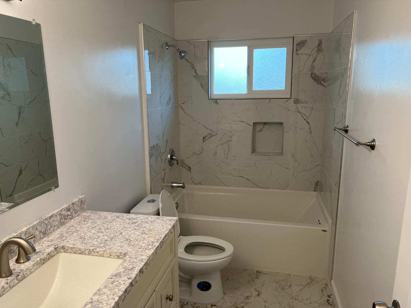 431 East St John Street San Jose, CA 95112 - Photo 25 of 32 a bathroom with a granite countertop sink a mirror a bathtub and shower