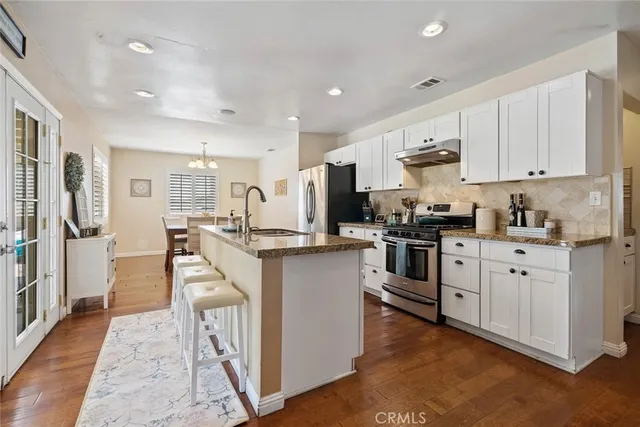 a kitchen with white cabinets and stainless steel appliances
