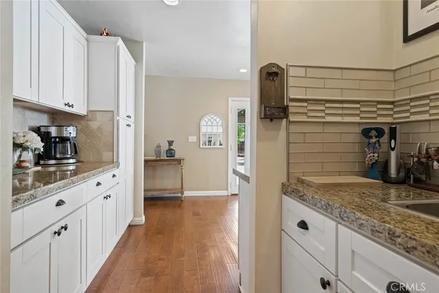 a kitchen with granite countertop white cabinets and stainless steel appliances