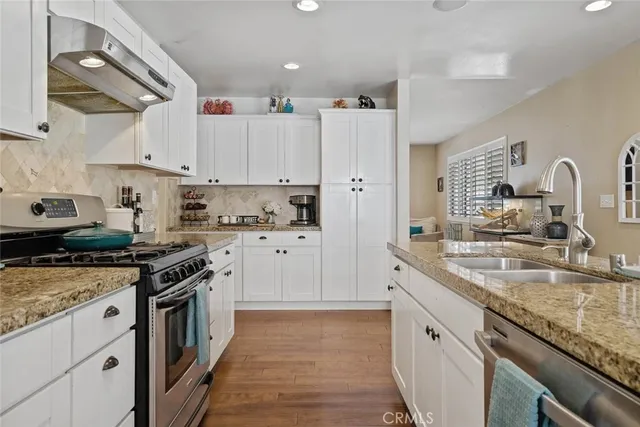 a kitchen with granite countertop a sink stainless steel appliances and cabinets