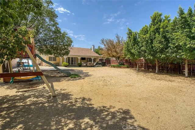 a view of swimming pool with lawn chairs and plants