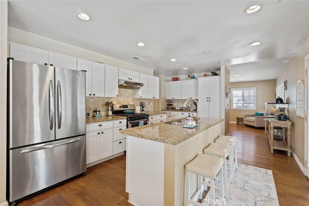 14022 Arlee Place Sylmar, CA 91342 - Photo 10 of 33 a kitchen with a refrigerator a stove a sink dishwasher a oven with white cabinets and wooden floor
