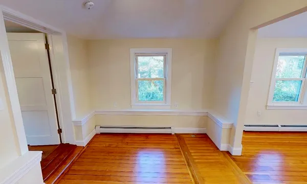 a view of room with window and wooden floor