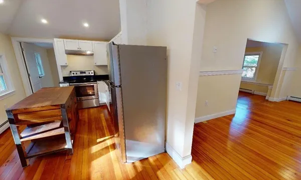 a view of a living room with furniture and wooden floor