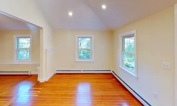 a view of empty room with window and wooden floor