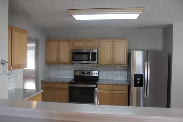a kitchen with a refrigerator and a stove top oven