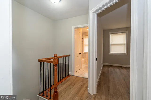 a view of a hallway with wooden floor and a window