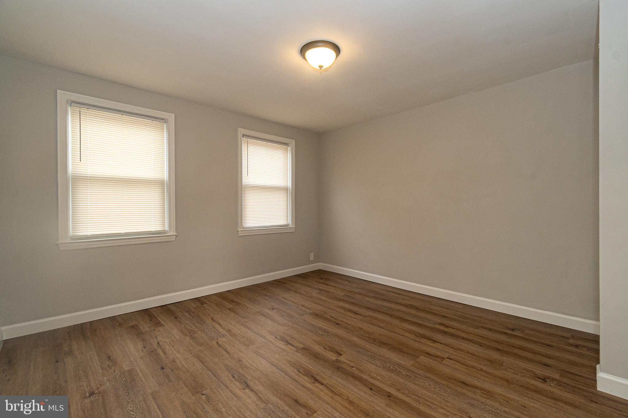 3716 Columbus Drive Baltimore, MD 21215 - Photo 17 of 36 a view of an empty room with wooden floor and a window