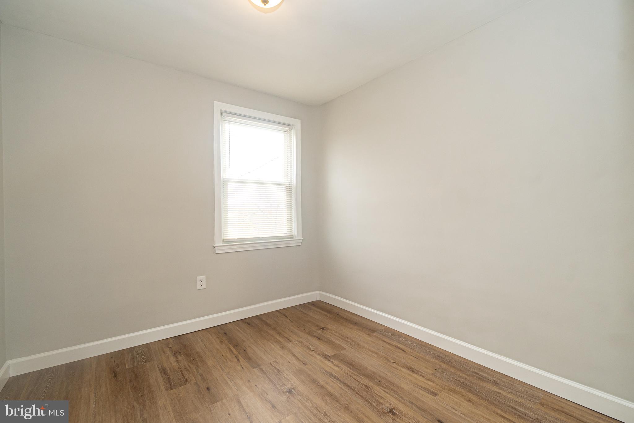 3716 Columbus Drive Baltimore, MD 21215 - Photo 21 of 36 a view of an empty room with wooden floor and a window