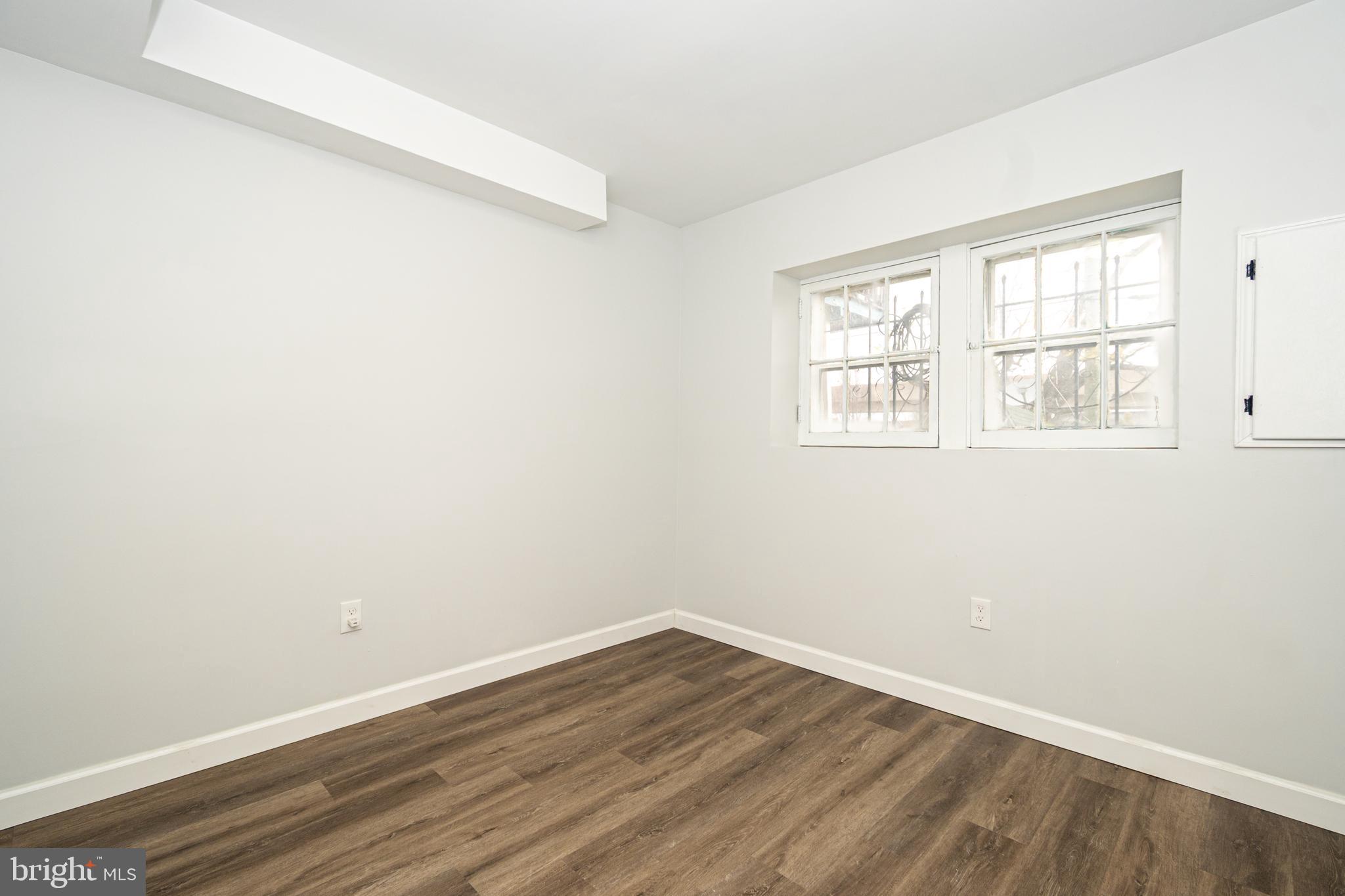 3716 Columbus Drive Baltimore, MD 21215 - Photo 27 of 36 an empty room with wooden floor and windows
