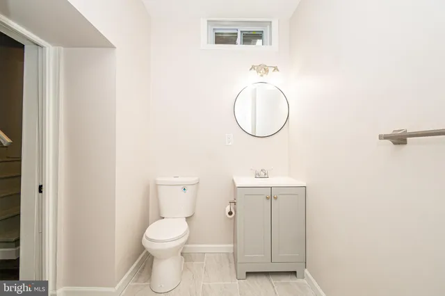 a bathroom with a toilet a sink and mirror