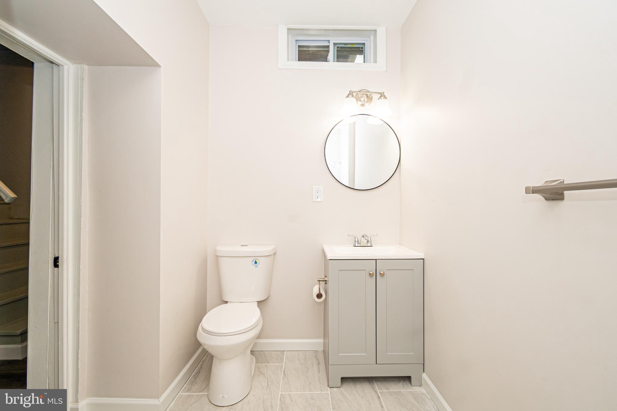 3716 Columbus Drive Baltimore, MD 21215 - Photo 28 of 36 a bathroom with a toilet a sink and mirror
