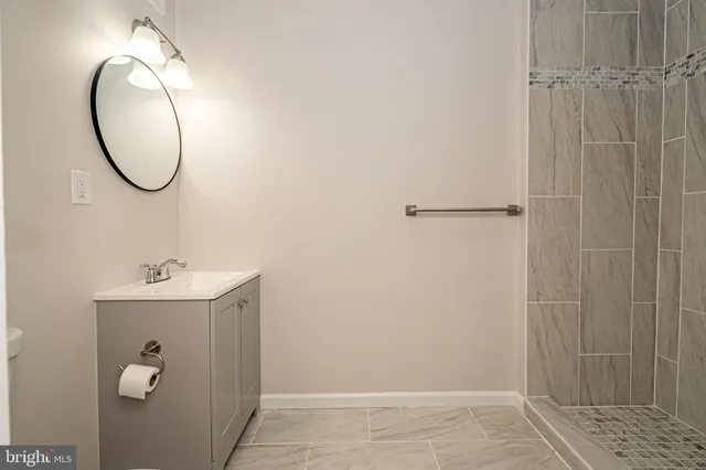 a bathroom with a sink a mirror and a shower