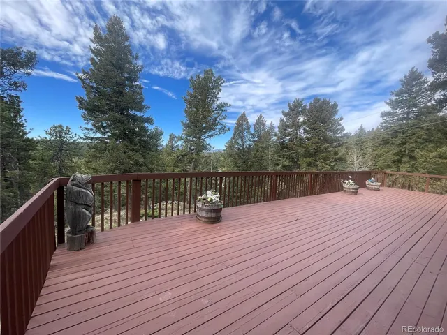 a view of stairs and deck with wooden floor and fence