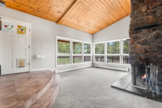a view of an empty room with a fireplace and a large window