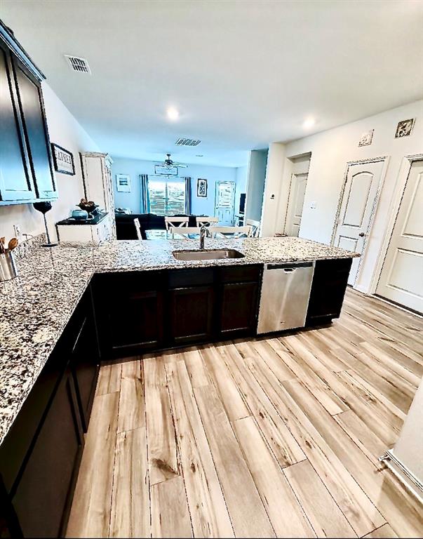 196 Cattlemans Crk Road West Newark, TX 76071 - Photo 4 of 31 Gourmet kitchen featuring a large island with an undermount stainless steel sink, granite countertops, and dark wood cabinetry