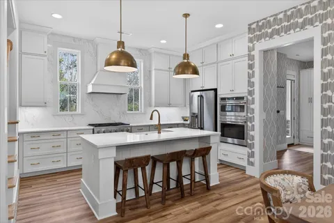 a kitchen with stainless steel appliances granite countertop a sink a stove a refrigerator and island