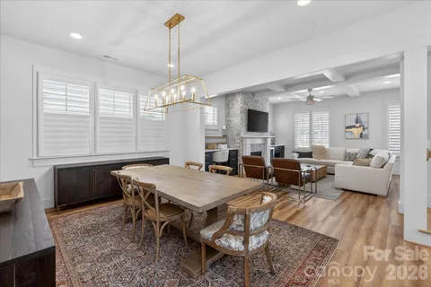 a kitchen with stainless steel appliances granite countertop a dining table chairs sink and stove top oven