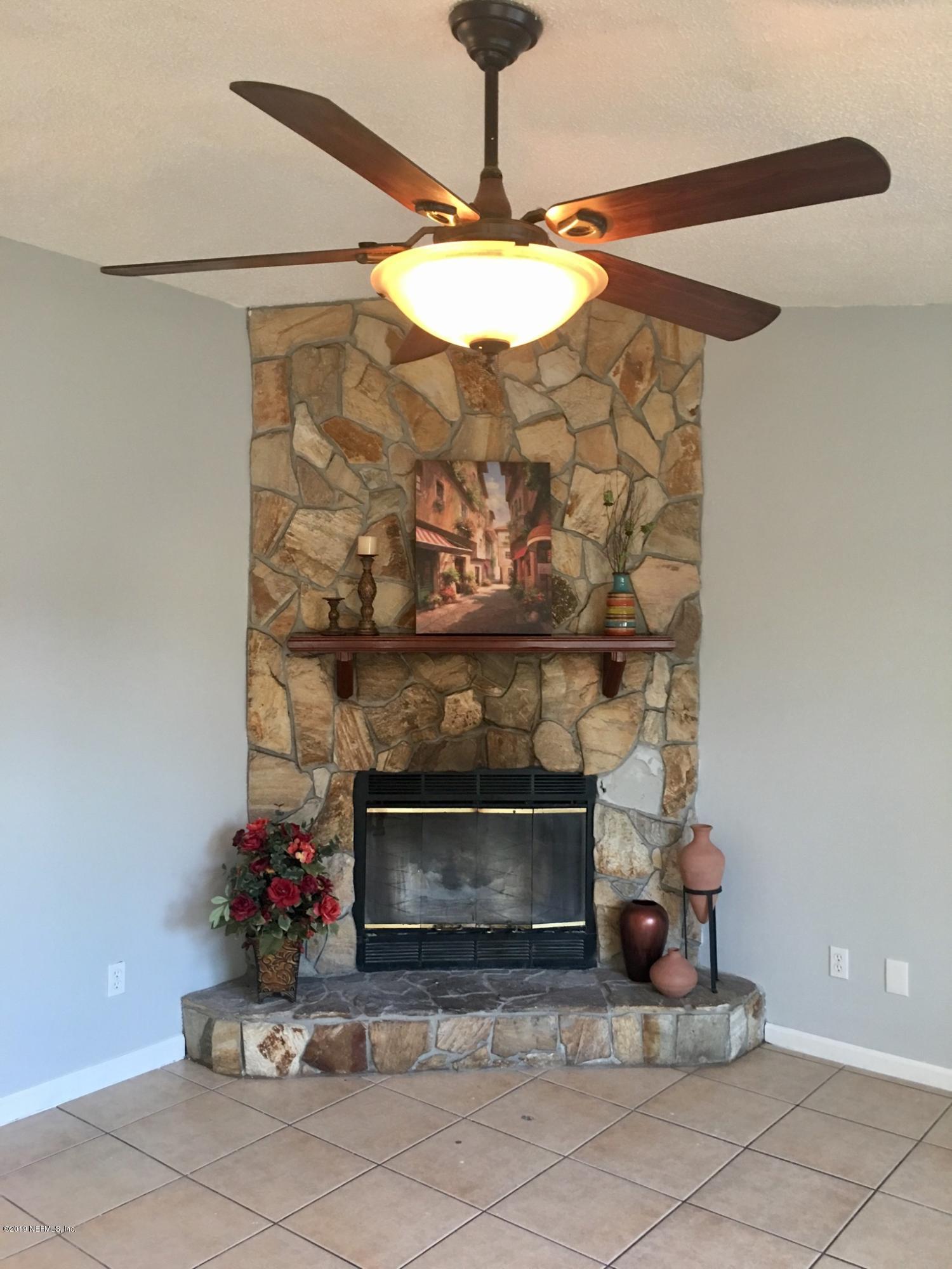 8224 Pear Road Jacksonville, FL 32210 - Photo 2 of 7 a table with a fireplace and a chandelier