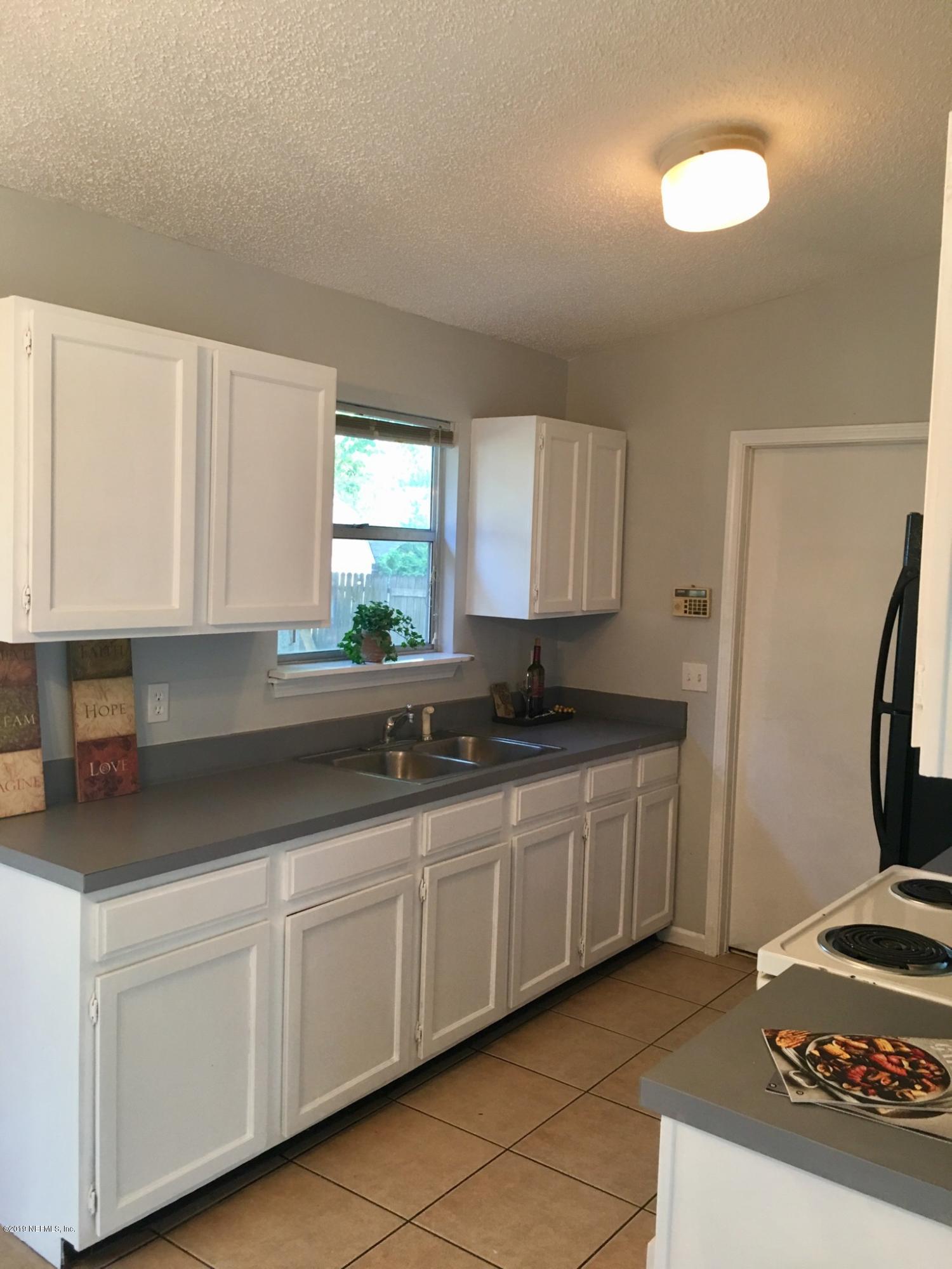 8224 Pear Road Jacksonville, FL 32210 - Photo 3 of 7 a kitchen with stainless steel appliances granite countertop a sink stove and cabinets