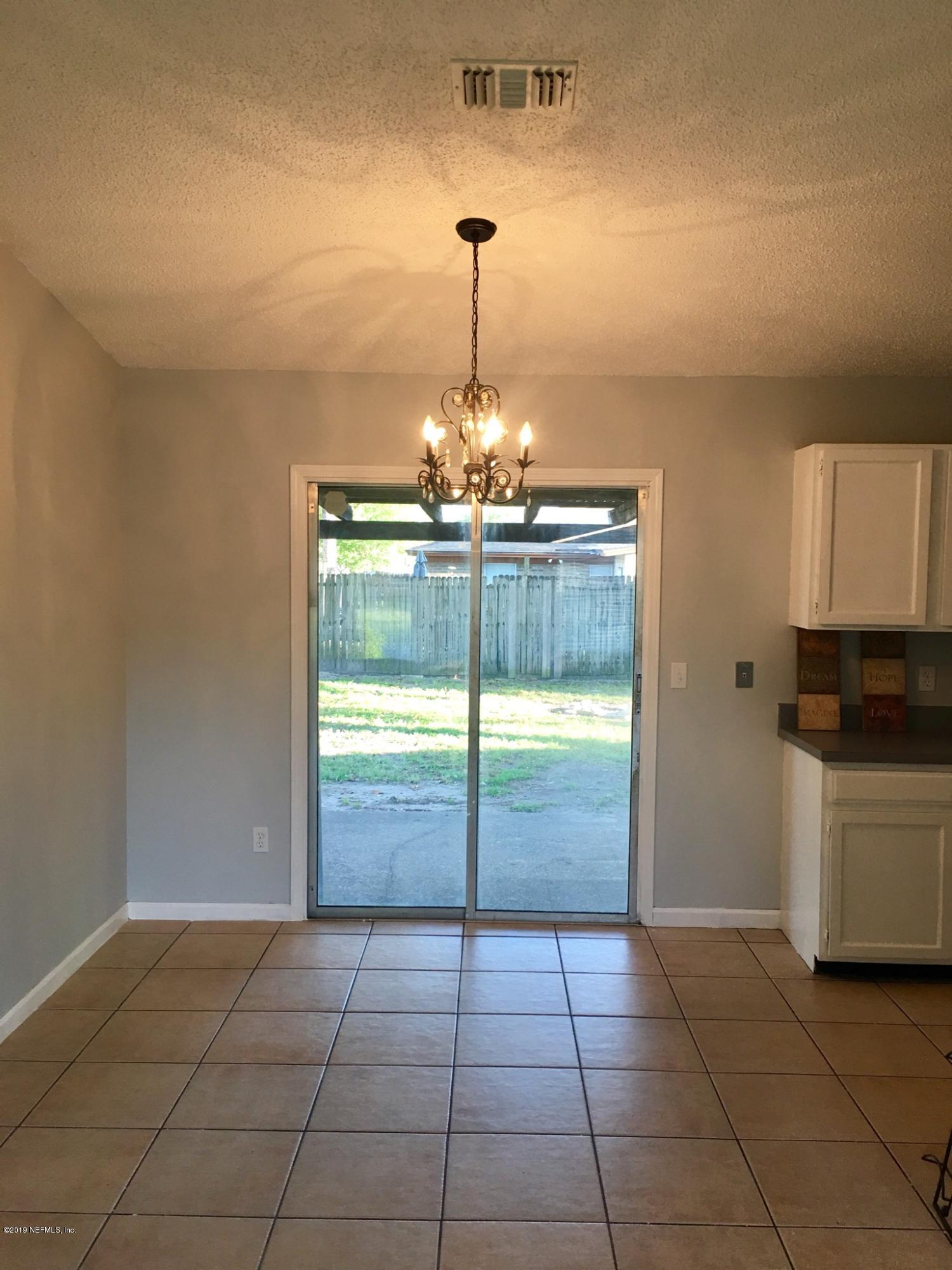 8224 Pear Road Jacksonville, FL 32210 - Photo 4 of 7 a room with a chandelier and kitchen view