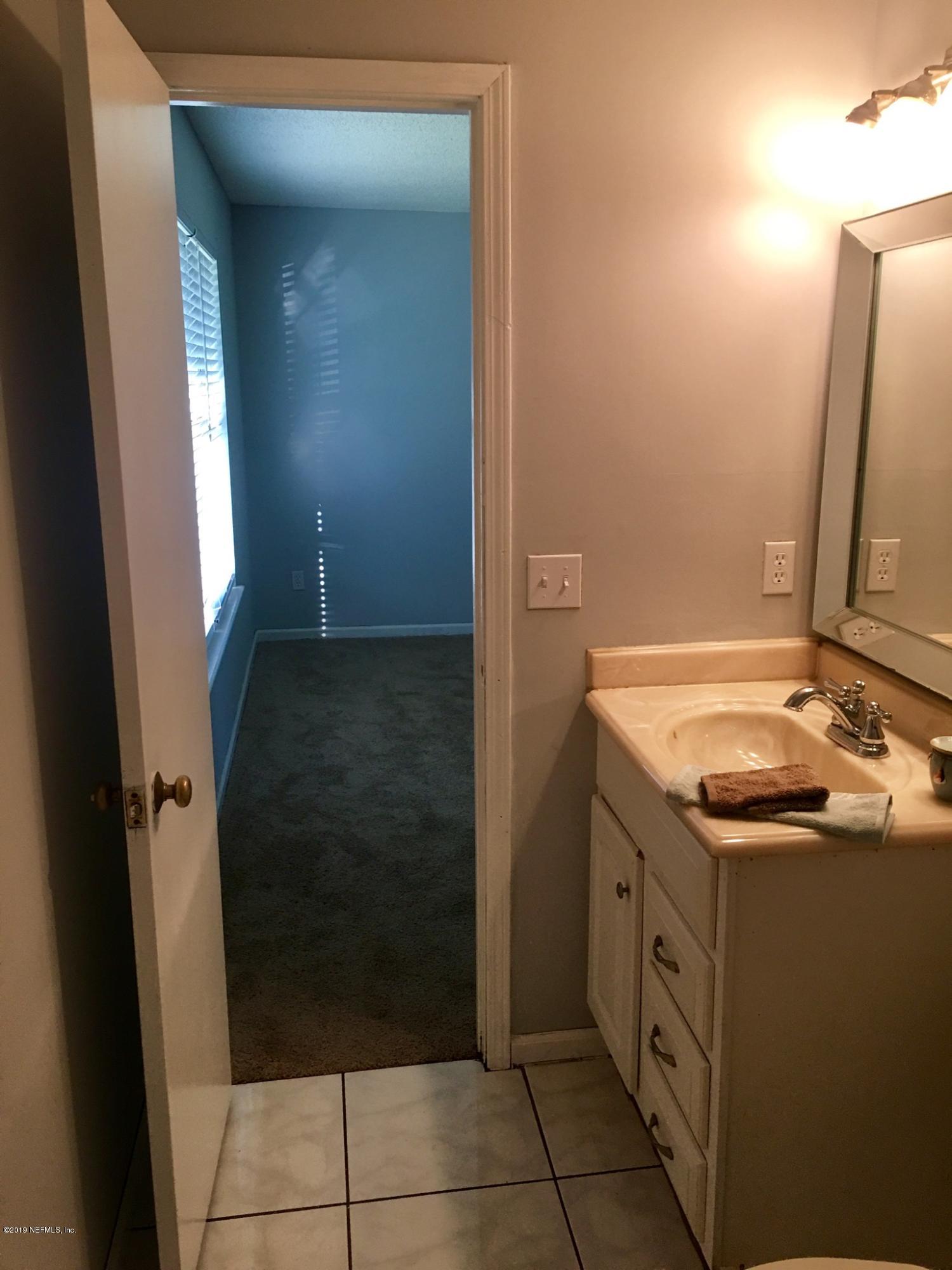 8224 Pear Road Jacksonville, FL 32210 - Photo 5 of 7 a bathroom with a sink and a mirror