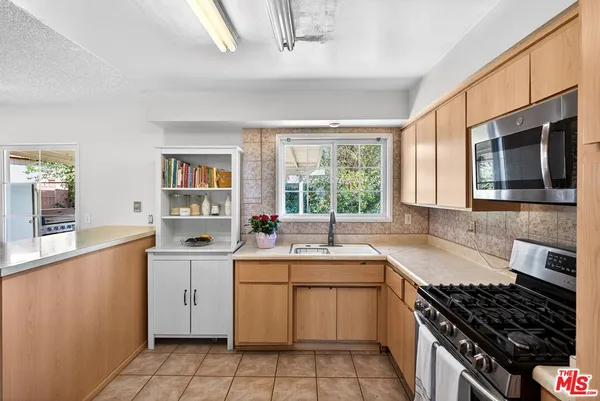 a kitchen that has a sink and a stove in it