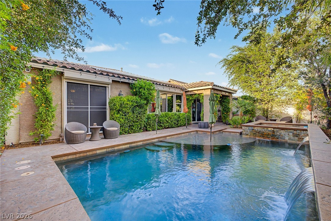 7415 Campbell Ranch Avenue Las Vegas, NV 89179 - Photo 51 of 52 An inviting backyard oasis offers a sparkling pool with a cascading water feature and an integrated spa.