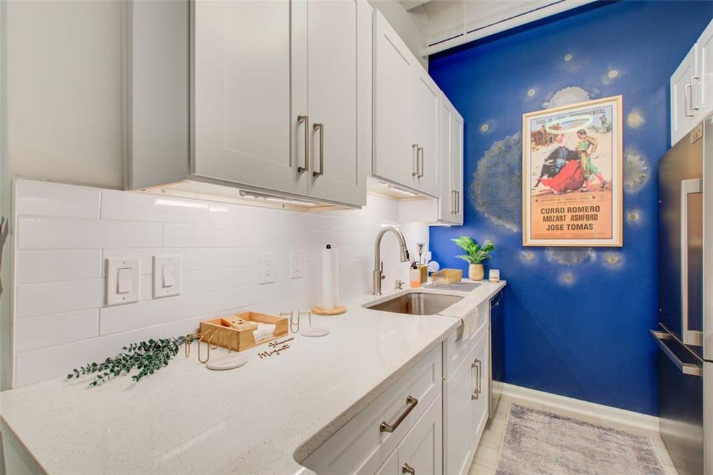 32 Peachtree Street Northwest, Unit 1102 Atlanta, GA 30303 - Photo 29 of 35 a kitchen with stainless steel appliances a sink a stove and white cabinets