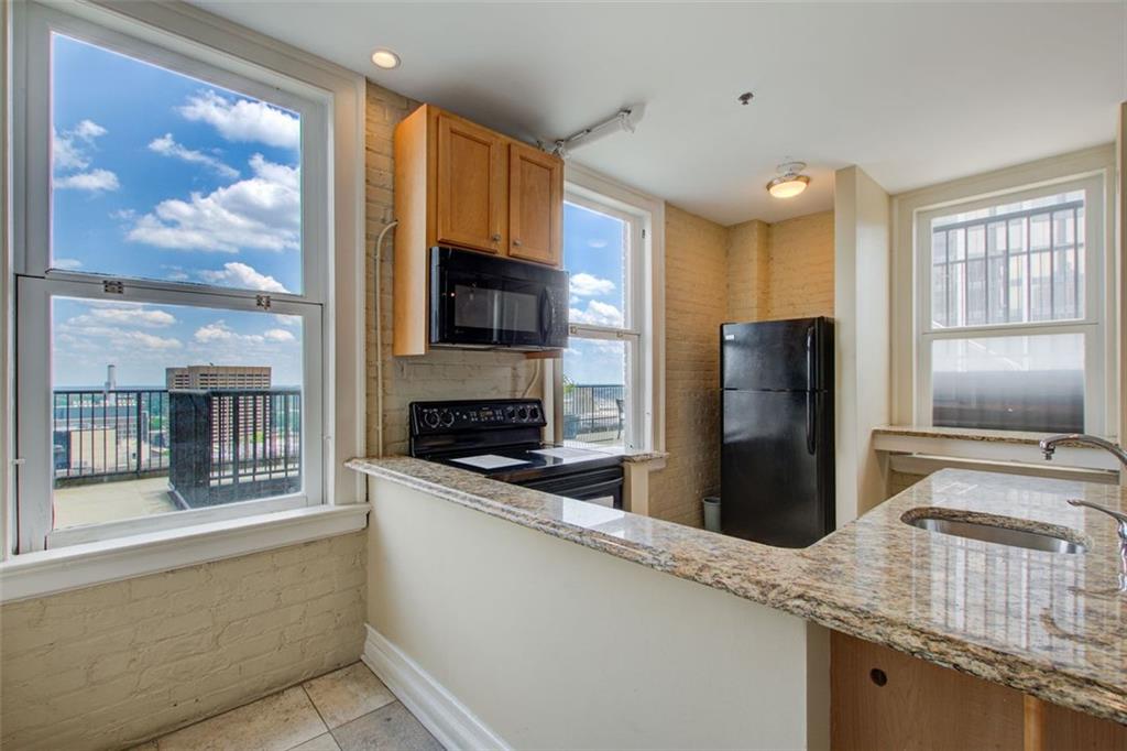 32 Peachtree Street Northwest, Unit 1102 Atlanta, GA 30303 - Photo 8 of 35 a kitchen with a refrigerator and a sink