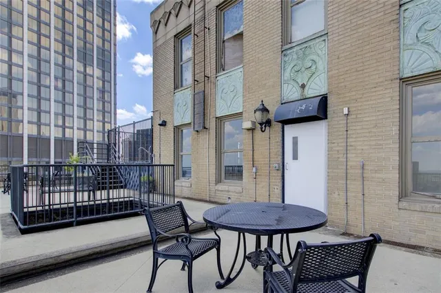 a view of a balcony with chairs and a potted plant