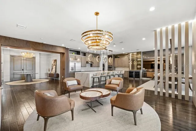 a kitchen with stainless steel appliances kitchen island granite countertop a table chairs in it and wooden floors