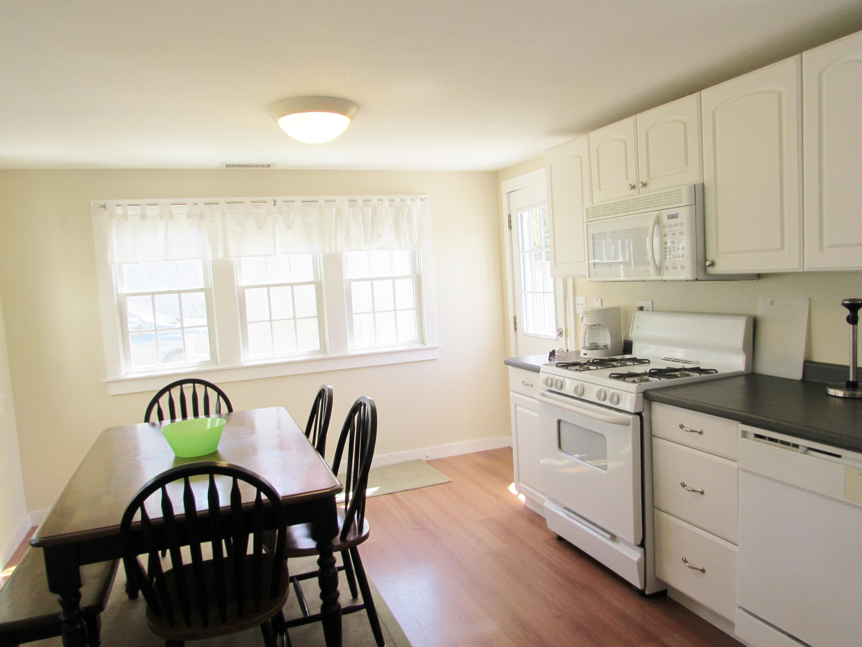 41 Longell Road Dennis Port, MA 02639 - Photo 3 of 14 a kitchen with stainless steel appliances granite countertop a stove a sink dishwasher a dining table and chairs with wooden floor