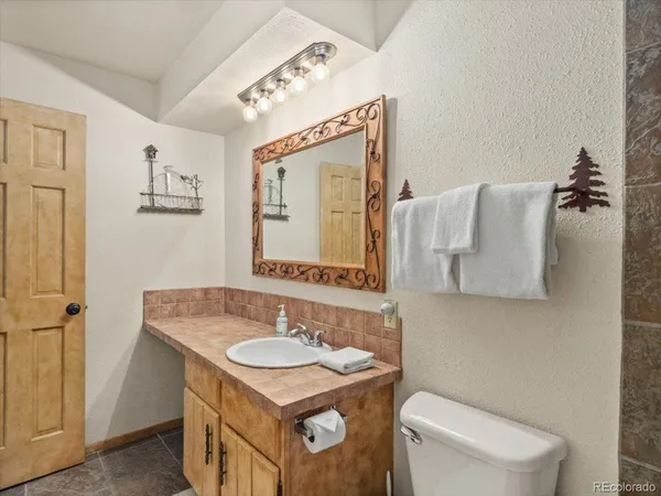 a bathroom with a sink toilet and mirror