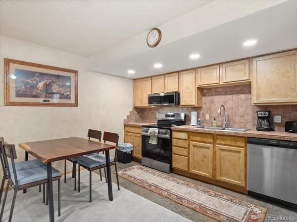 a kitchen with a table chairs microwave and cabinets