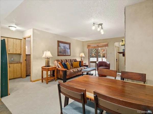 a living room with furniture a chandelier fan and a dining table