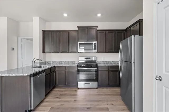 a kitchen with granite countertop stainless steel appliances and wooden cabinets