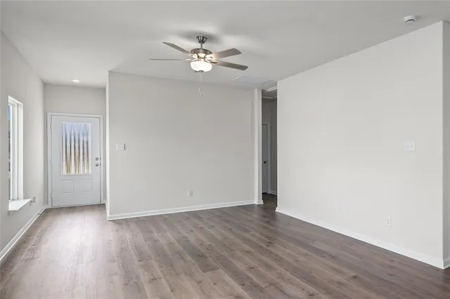 a view of an empty room with wooden floor