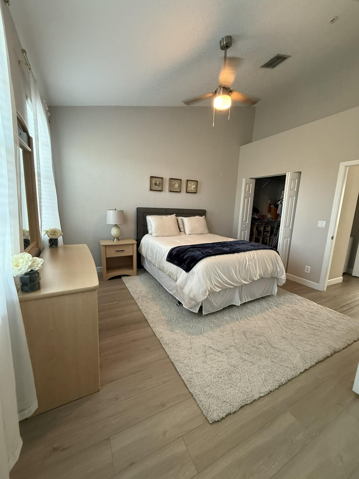 110 Sea Plum Drive, Unit 103 Jupiter, FL 33458 - Photo 16 of 31 a bedroom with a bed and a chandelier