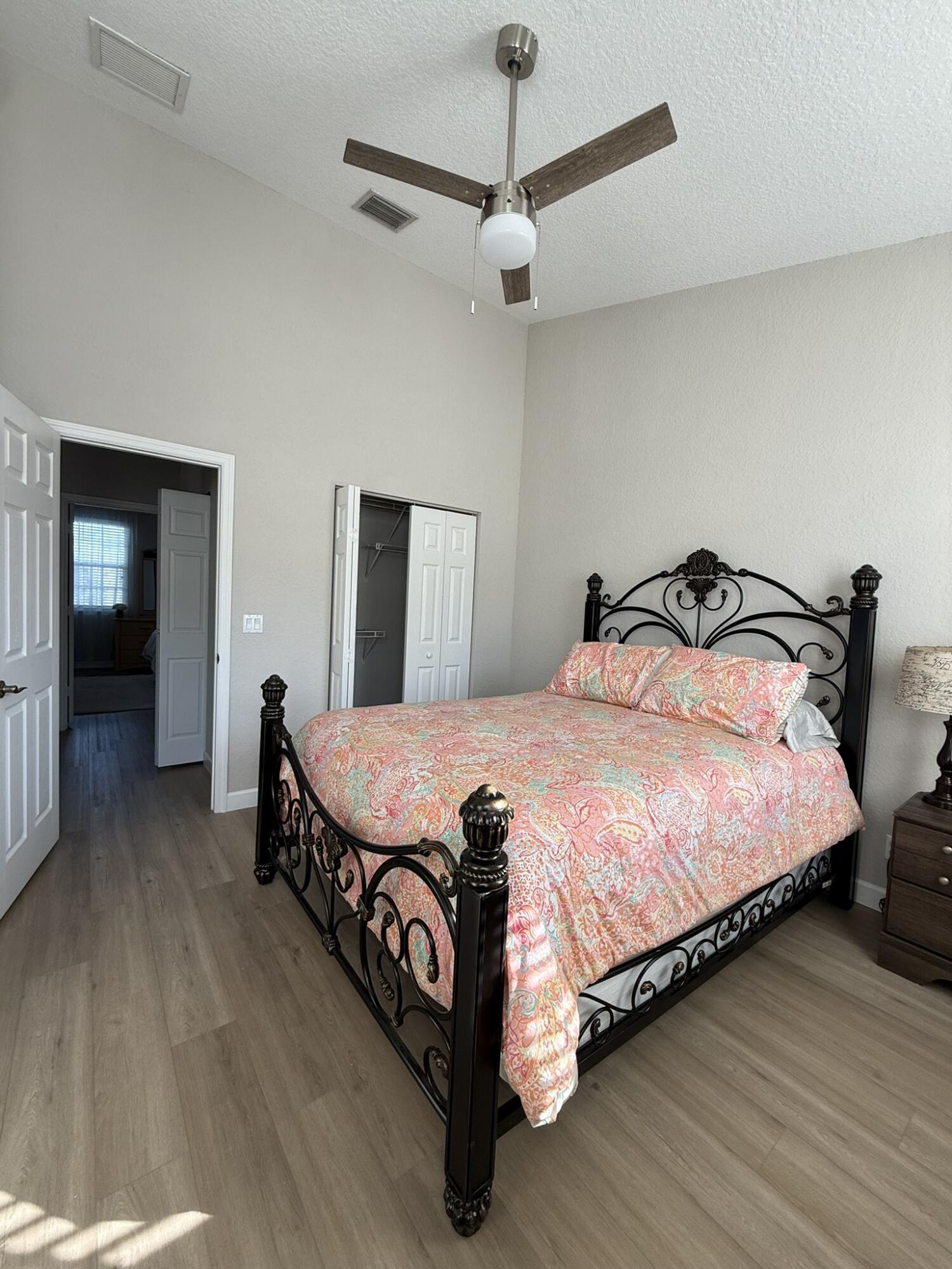 110 Sea Plum Drive, Unit 103 Jupiter, FL 33458 - Photo 19 of 31 a bedroom with a bed and wooden floor