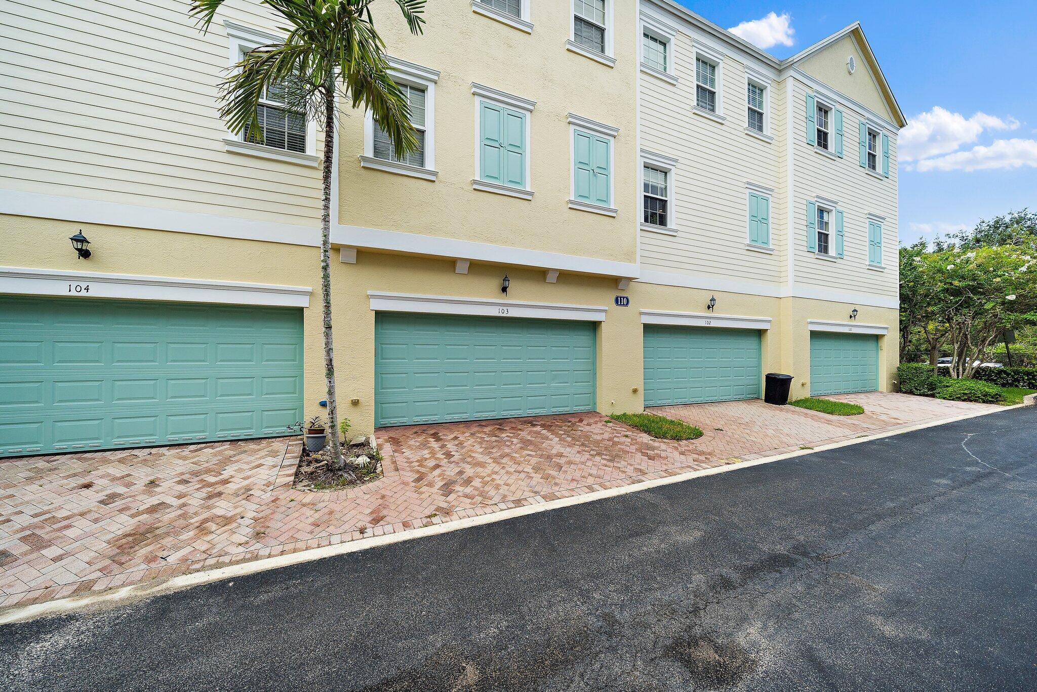 110 Sea Plum Drive, Unit 103 Jupiter, FL 33458 - Photo 23 of 31 a front view of a house with a yard and garage