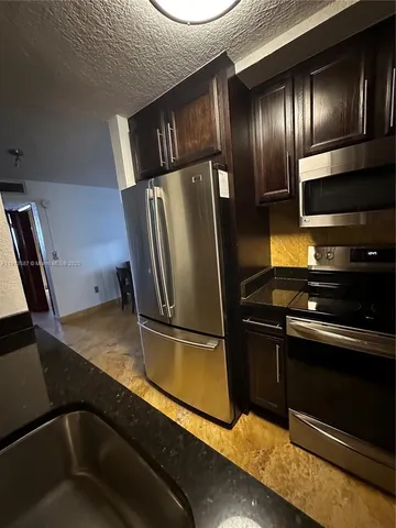 a metallic refrigerator freezer sitting inside of a kitchen