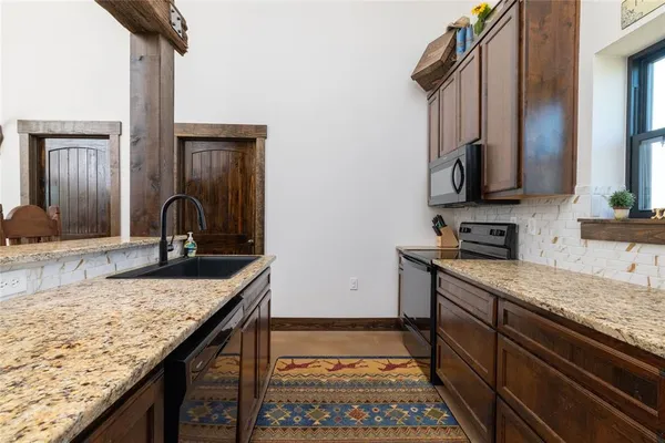 a kitchen with granite countertop stainless steel appliances and a sink