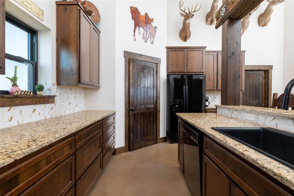 5543 Gray Road Nocona, TX 76255 - Photo 11 of 36 a kitchen with granite countertop a sink and refrigerator