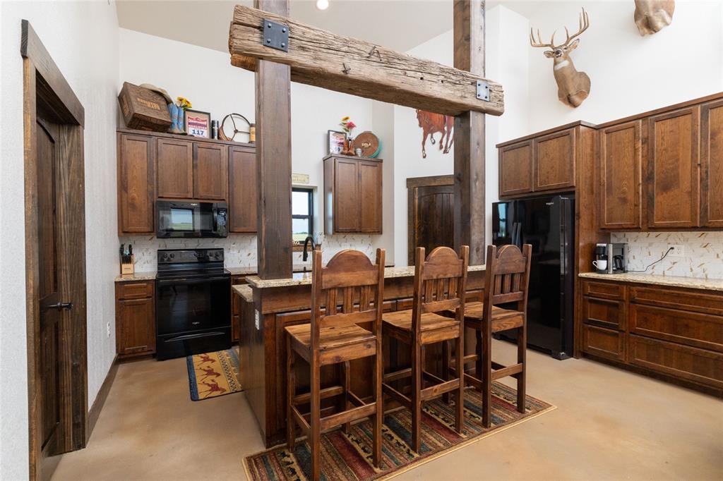 5543 Gray Road Nocona, TX 76255 - Photo 6 of 36 a kitchen with stainless steel appliances kitchen island granite countertop a refrigerator and microwave