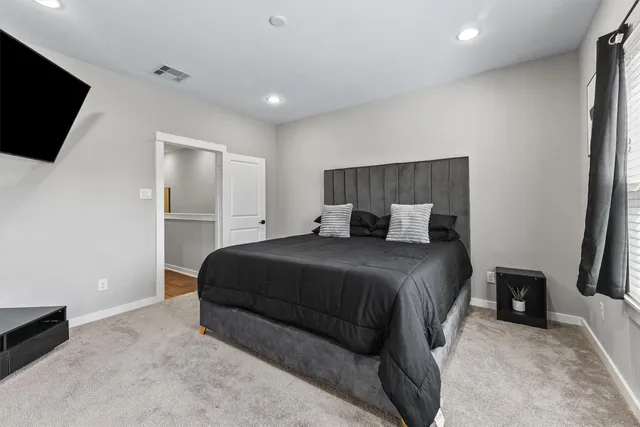 a bedroom with a bed and a flat screen tv