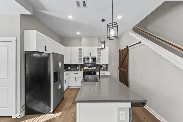 a kitchen with refrigerator and chairs