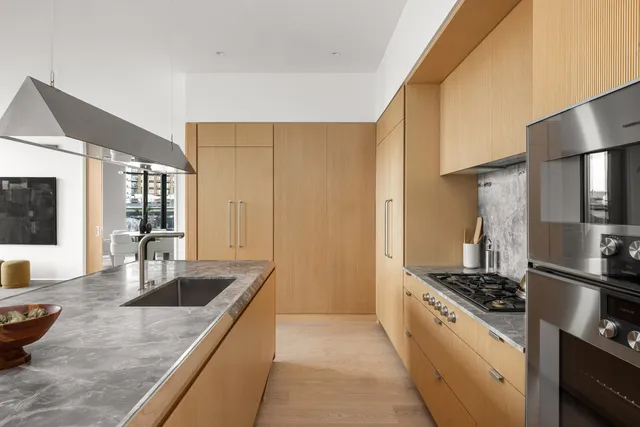 a kitchen with kitchen island a sink a counter appliances and cabinets