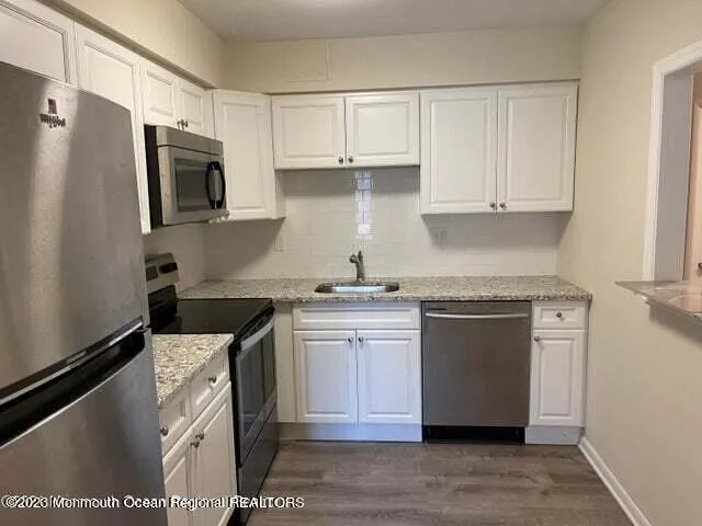 a kitchen with stainless steel appliances granite countertop a stove a sink and a refrigerator