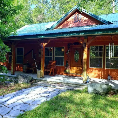 a view of a house with backyard porch and sitting area